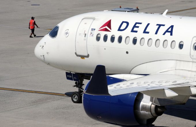 A Delta jumbo jet featuring its signature white color and blue engines
