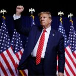 Donald Trump wearing an elegant suit, raising his right hand as a symbol of power