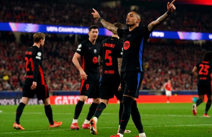 Raphinha, Barcelona player, celebrating with his arms raised after scoring the winning goal against Benfica