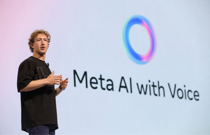 Mark Zuckerberg speaking at a META AI conference, wearing a black shirt with jeans and a slightly messy hairstyle