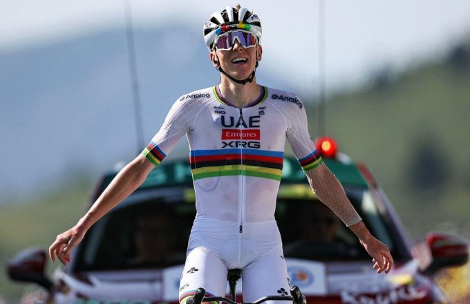 The great Slovenian cyclist riding his bike, wearing a white outfit with colored stripes around the abdomen area