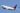 A white Delta Airlines plane flying across a vast blue sky