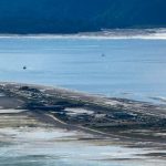A small town in the middle of the sea with a mountain behind it