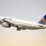A large United Airlines plane soaring through the vast blue sky