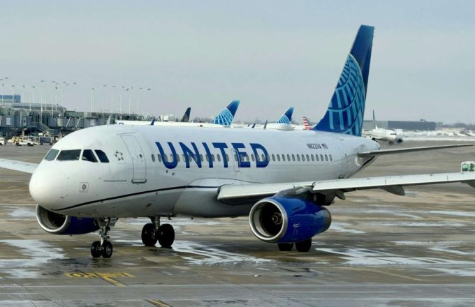 A large United Airlines plane standing still on the runway
