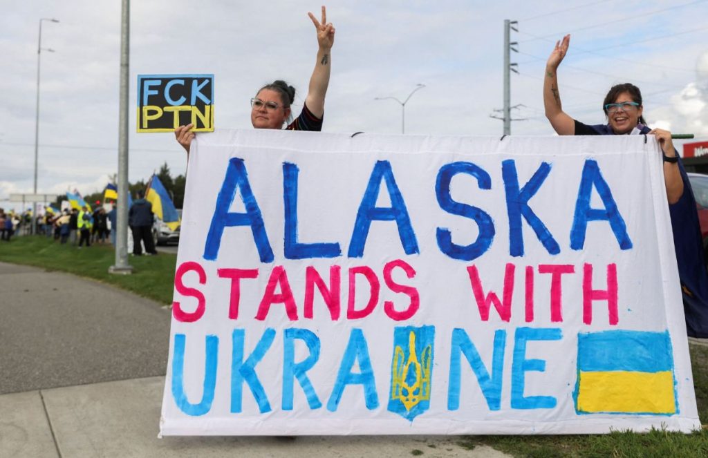 Two people holding a sign in the middle of the protests in Alaska