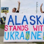 Two people holding a sign in the middle of the protests in Alaska
