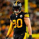 A Steelers player wearing a striking black football uniform with yellow stripes down the sides