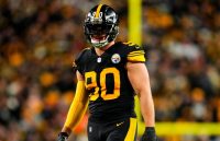 A Steelers player wearing a striking black football uniform with yellow stripes down the sides