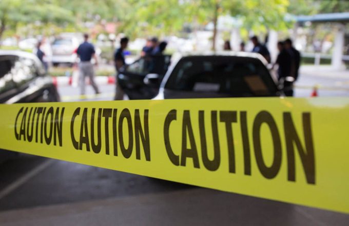 A crime scene surrounded by yellow tape that reads "caution"