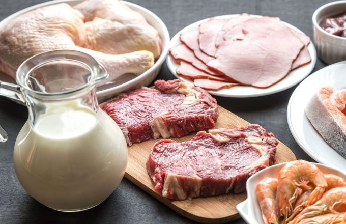 Milk, meat, shrimp, ham, and raw chicken on a table