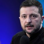 The Ukrainian president with long hair and a beard, staring intently at the audience while giving a speech