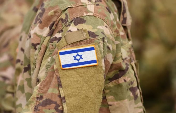 An Israeli soldier wearing a camouflage uniform with the Israeli flag on the shoulder