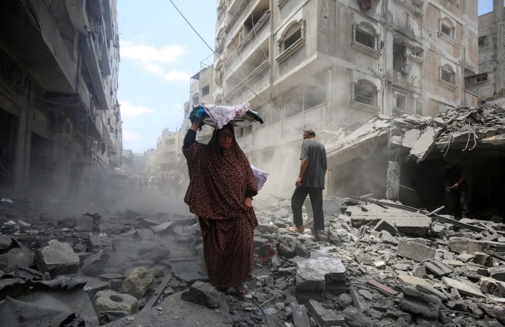 A woman walking over the rubble after the attacks in Gaza