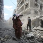 A woman walking over the rubble after the attacks in Gaza