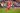 Luis Díaz running across the field in Bayern’s striking new red uniform while looking happy