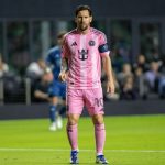 Messi on the field wearing Inter Miami’s pink uniform, about to strike the ball