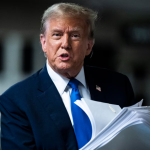 The President of the United States looking very serious while holding papers in his left hand