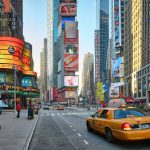 The colorful street of Times Square, filled with tall buildings and huge screens