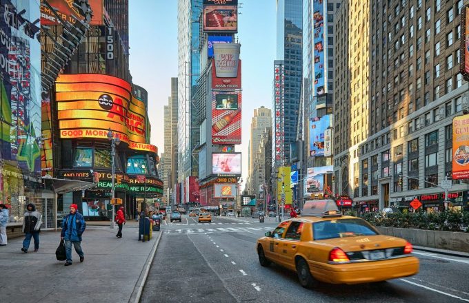 The colorful street of Times Square, filled with tall buildings and huge screens