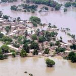An aerial view of a Pakistani city with water reaching up to the rooftops due to flooding