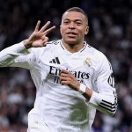 Mbappé celebrating a hat trick by holding up three fingers with his hand while running