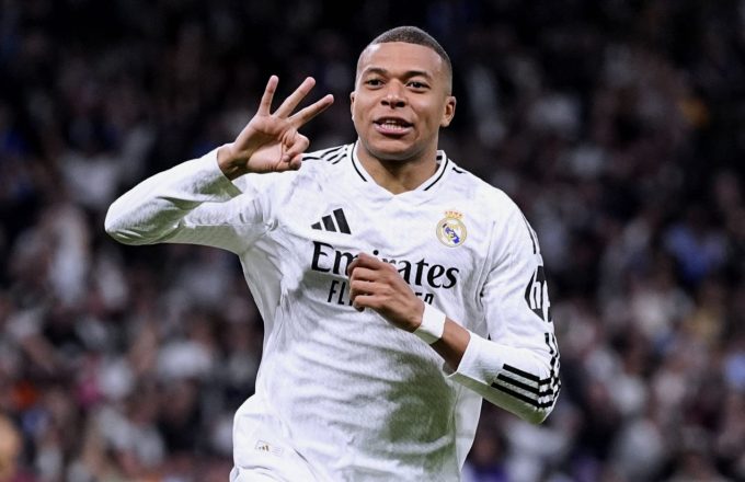 Mbappé celebrating a hat trick by holding up three fingers with his hand while running