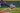 A Rockies player stretching his arm across the ground to catch the ball and tag the Dodgers player