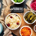 A kitchen table with some healthy foods and a small label on the side that says “Probiotics.”