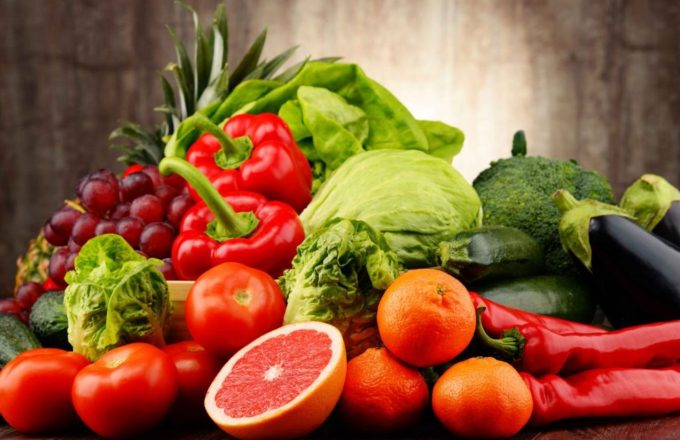 Several fruits and vegetables arranged on a kitchen counter on top of a table
