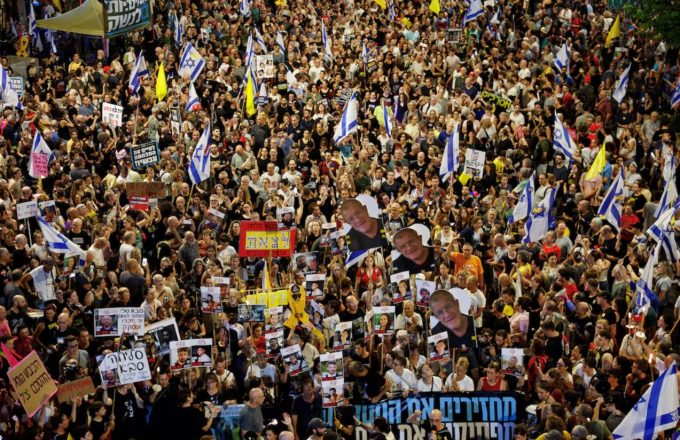 A crowd of people marching in the middle of the street