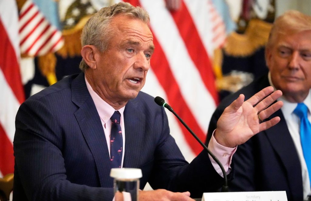 A man wearing a suit delivering what appears to be news at a press conference