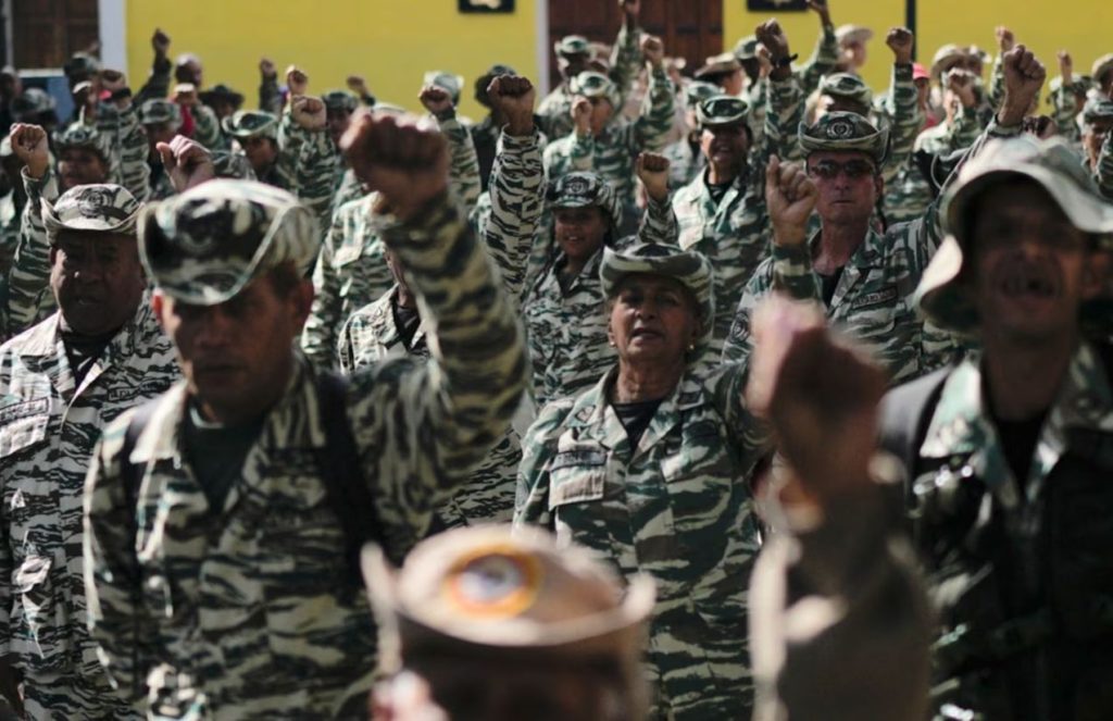 Different rows of Venezuelan military troops standing in formation with their left hands raised