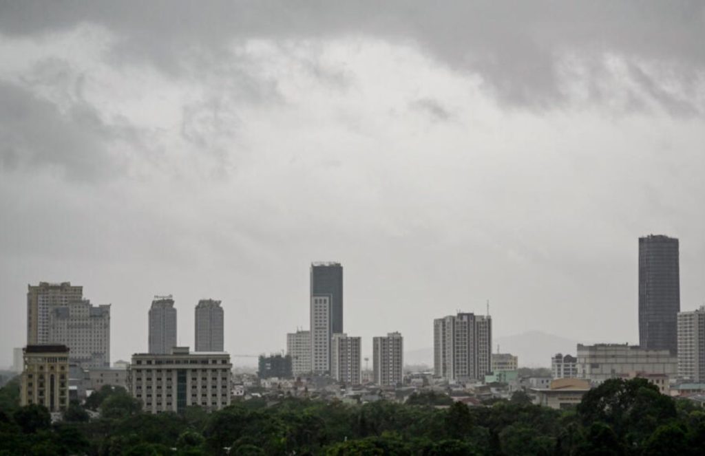 A panoramic view of a Vietnamese city covered in heavy clouds and rain