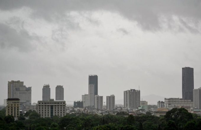 A panoramic view of a Vietnamese city covered in heavy clouds and rain