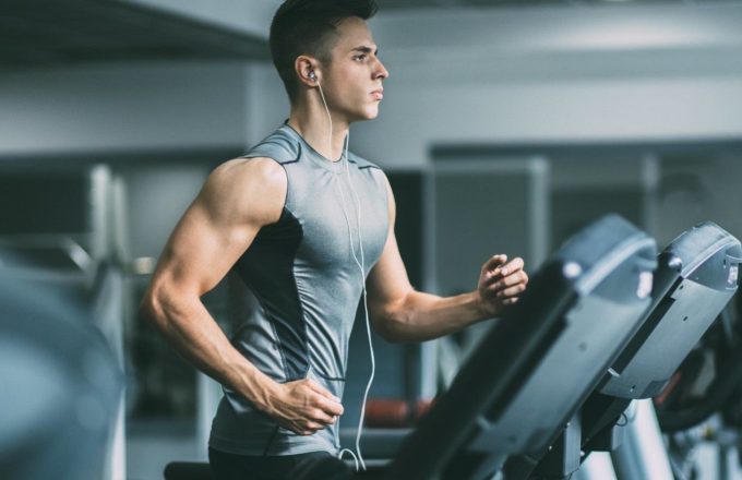 A man running on a treadmill in a gym