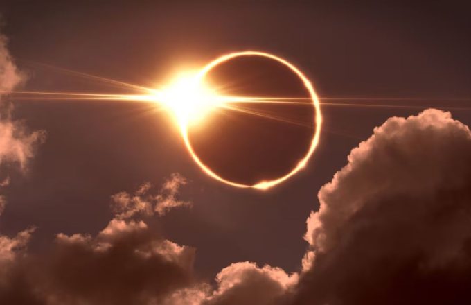 The sun being covered by the moon, creating a ring of light in the sky