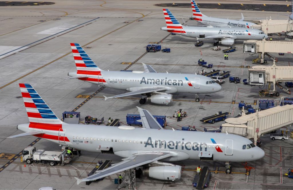 Several American Airlines planes parked at an airport waiting for all passengers to board