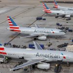 Several American Airlines planes parked at an airport waiting for all passengers to board