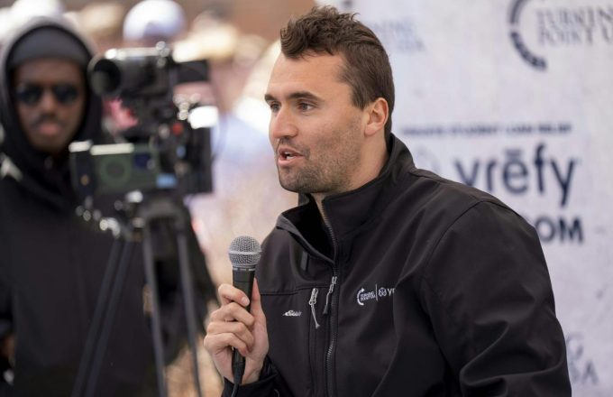 The American politician dressed entirely in black, holding a microphone and speaking in front of the cameras