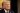 Trump casting a threatening yet confident look at the crowd while wearing an elegant black suit