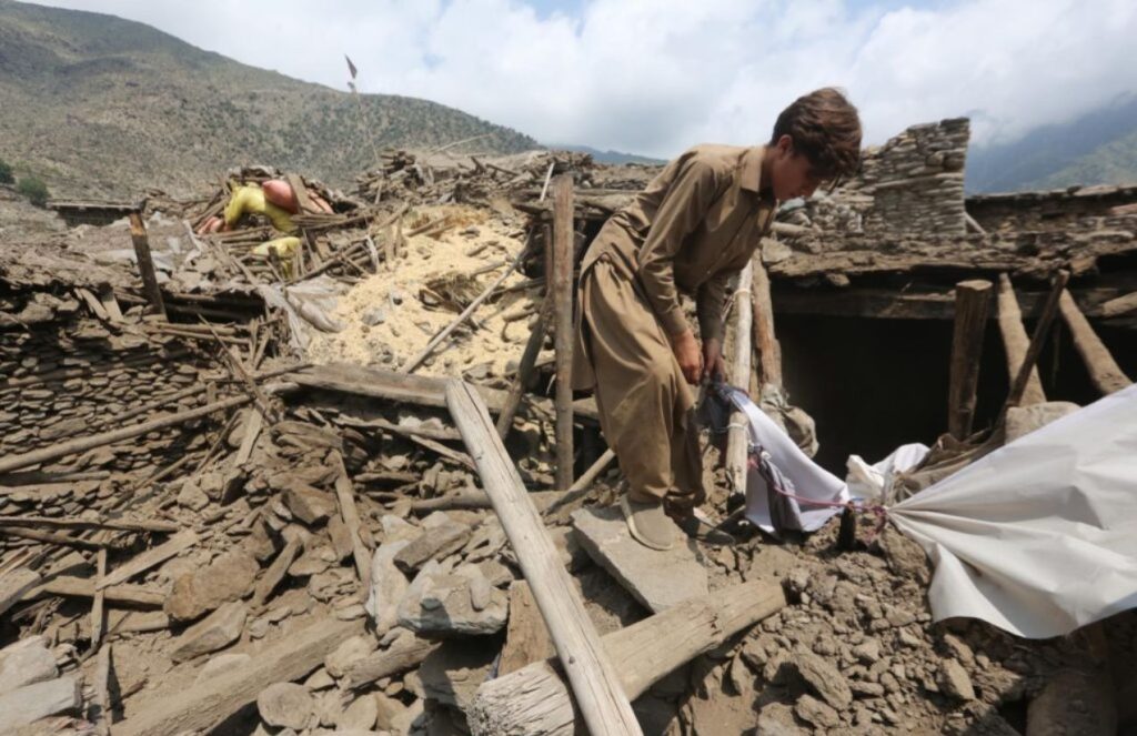 A person removing some debris from a house after the tragedy