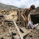 A person removing some debris from a house after the tragedy