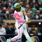 Tatis Jr. hitting a swing while wearing the Padres’ alternate white uniform