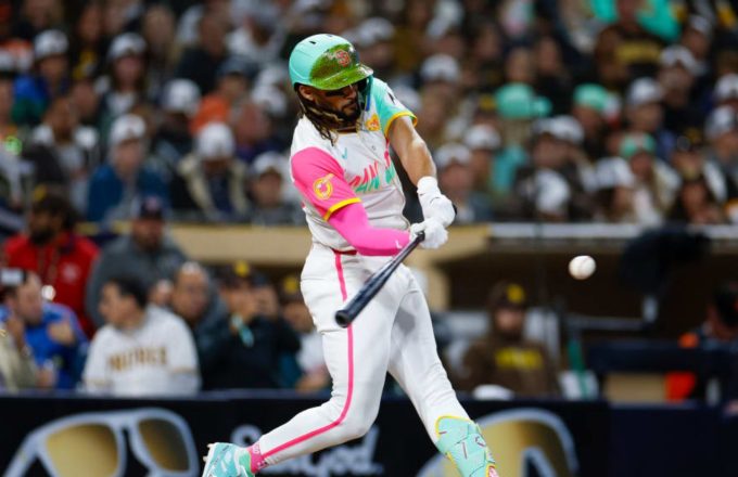 Tatis Jr. hitting a swing while wearing the Padres’ alternate white uniform