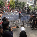 Young people in Nepal confronting the country’s police while breaking through a security barrier
