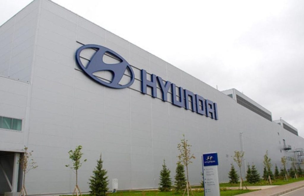 A large white-painted building with the word Hyundai on one of its walls