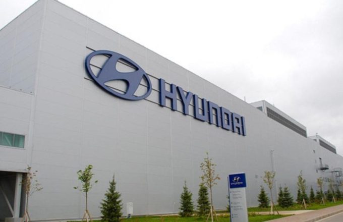 A large white-painted building with the word Hyundai on one of its walls