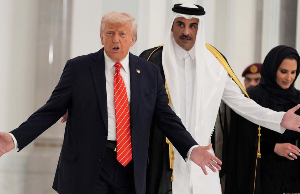 Donald Trump and the leader of Qatar walking down a hallway while raising their arms as if complaining about something
