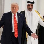 Donald Trump and the leader of Qatar walking down a hallway while raising their arms as if complaining about something